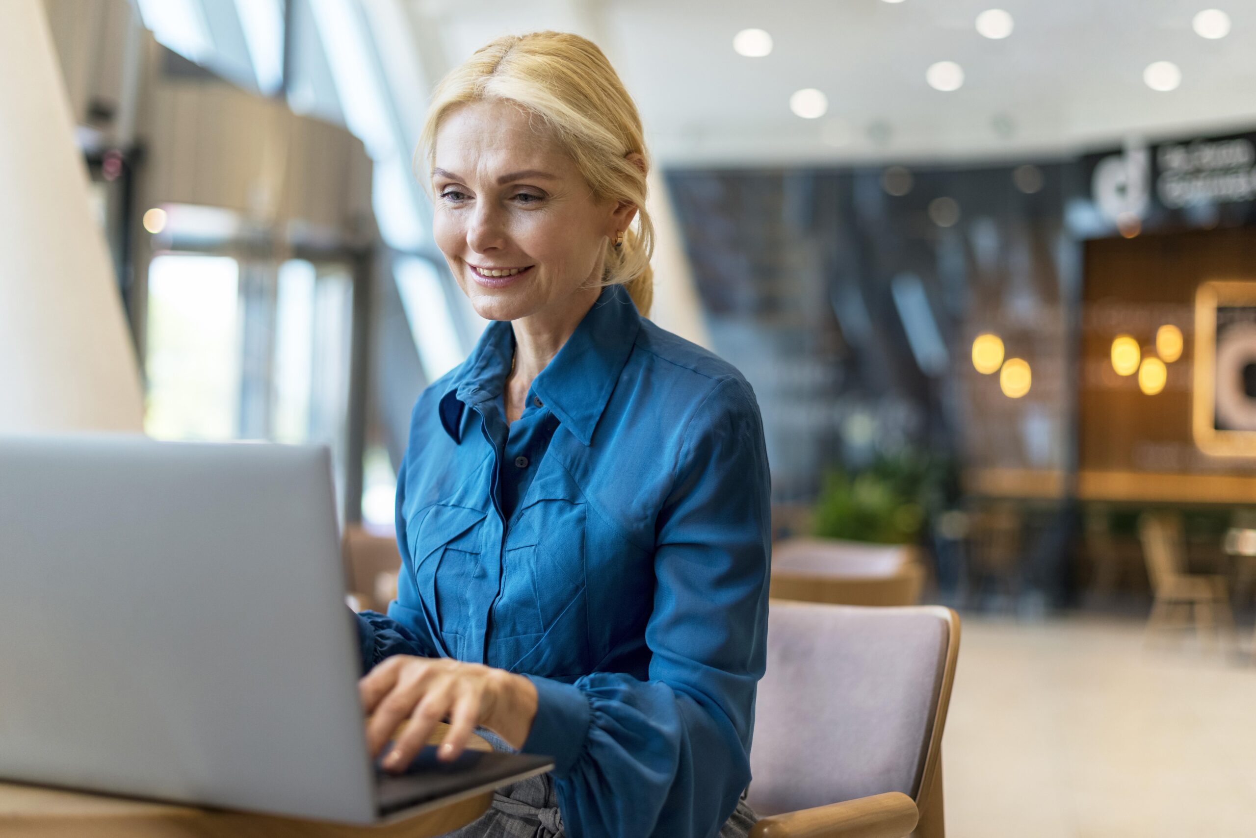 smiley-elder-business-woman-working-laptop-while-out